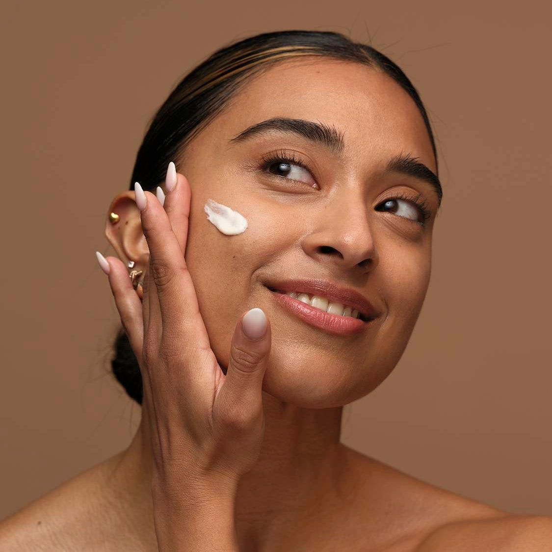 Woman applying cream on her face