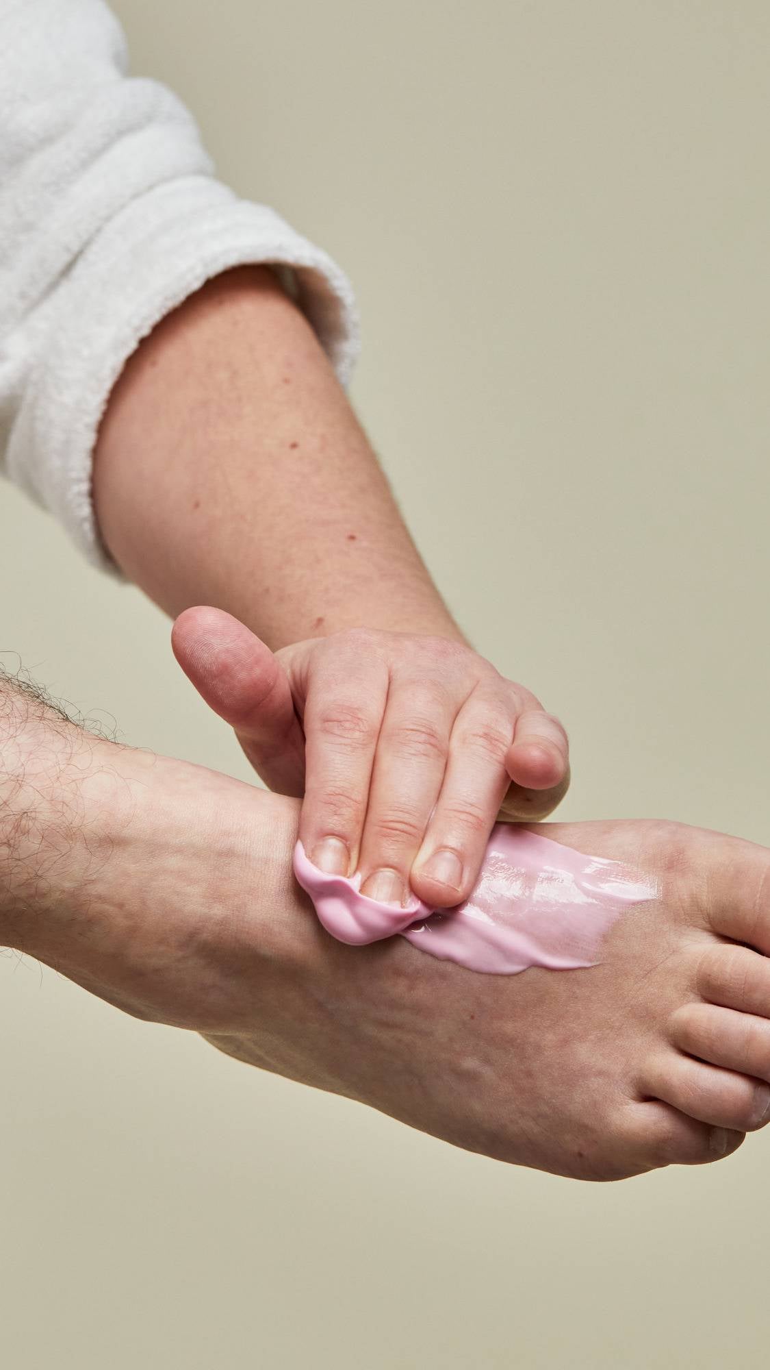 A person applying lotion on his foot