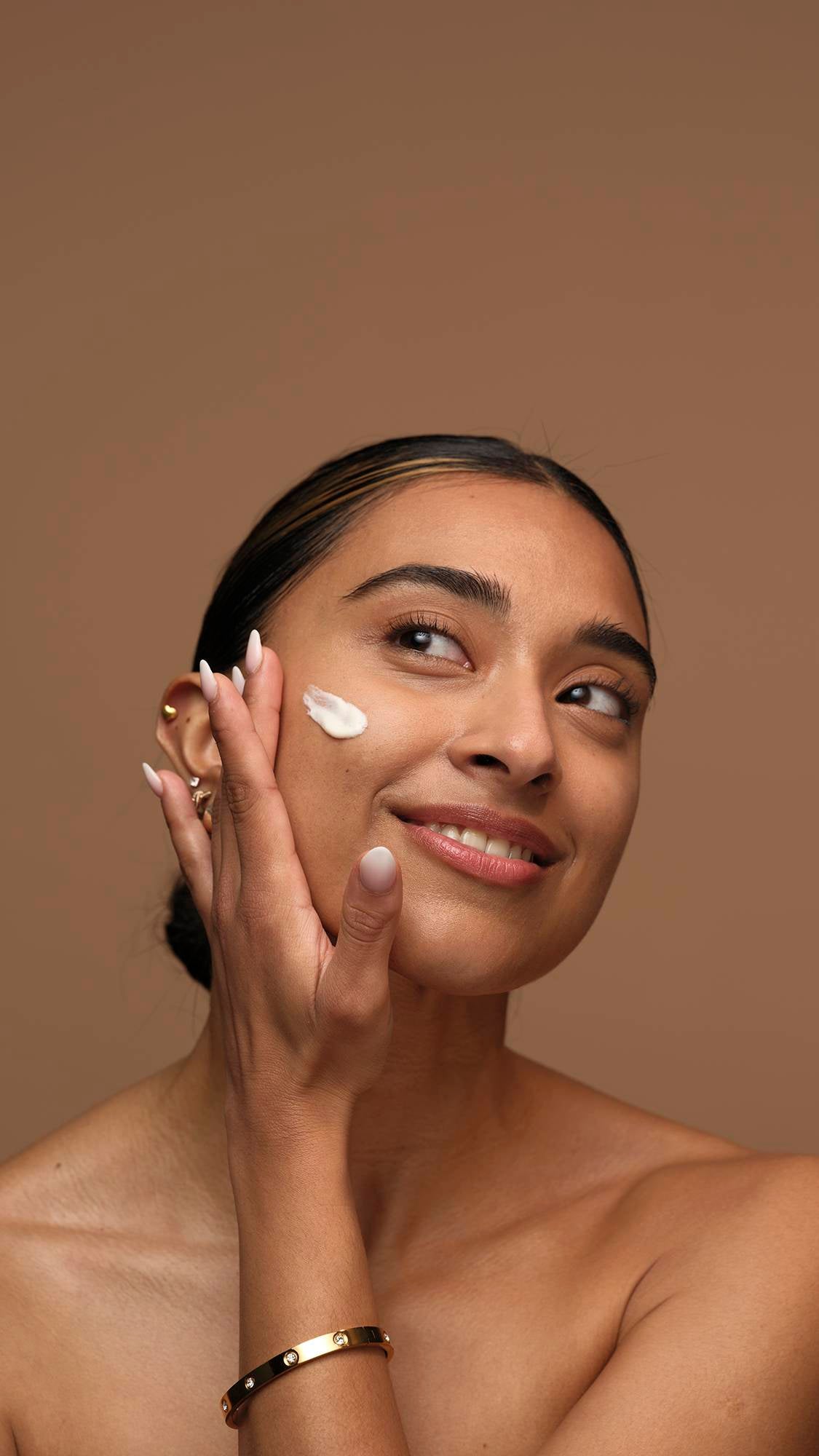 Woman applying cream on her face