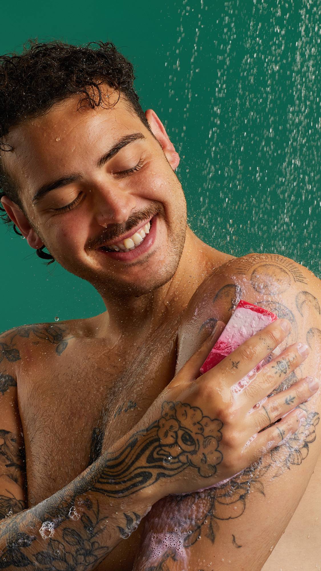 happily men scrubbing The Comforter Soap on his shoulder