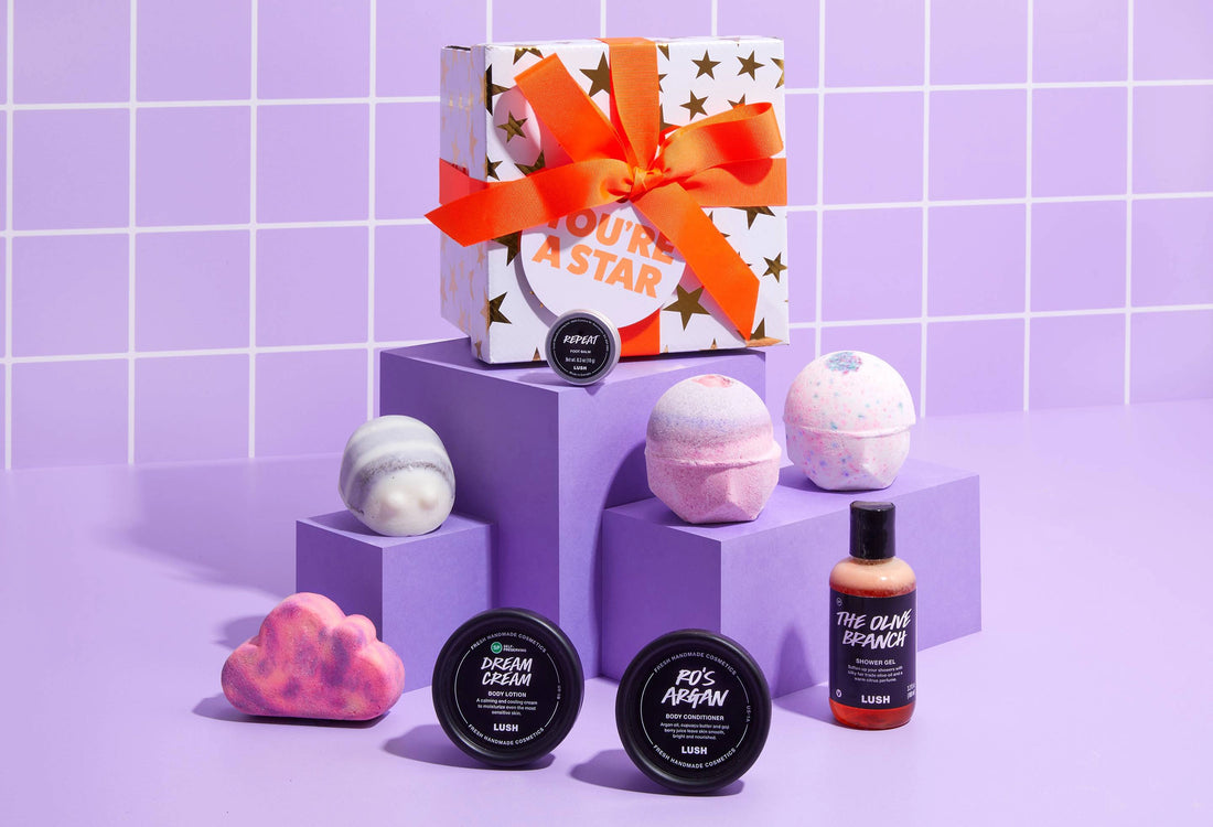 Bath products including bath bombs and soaps on a purple tiled background
