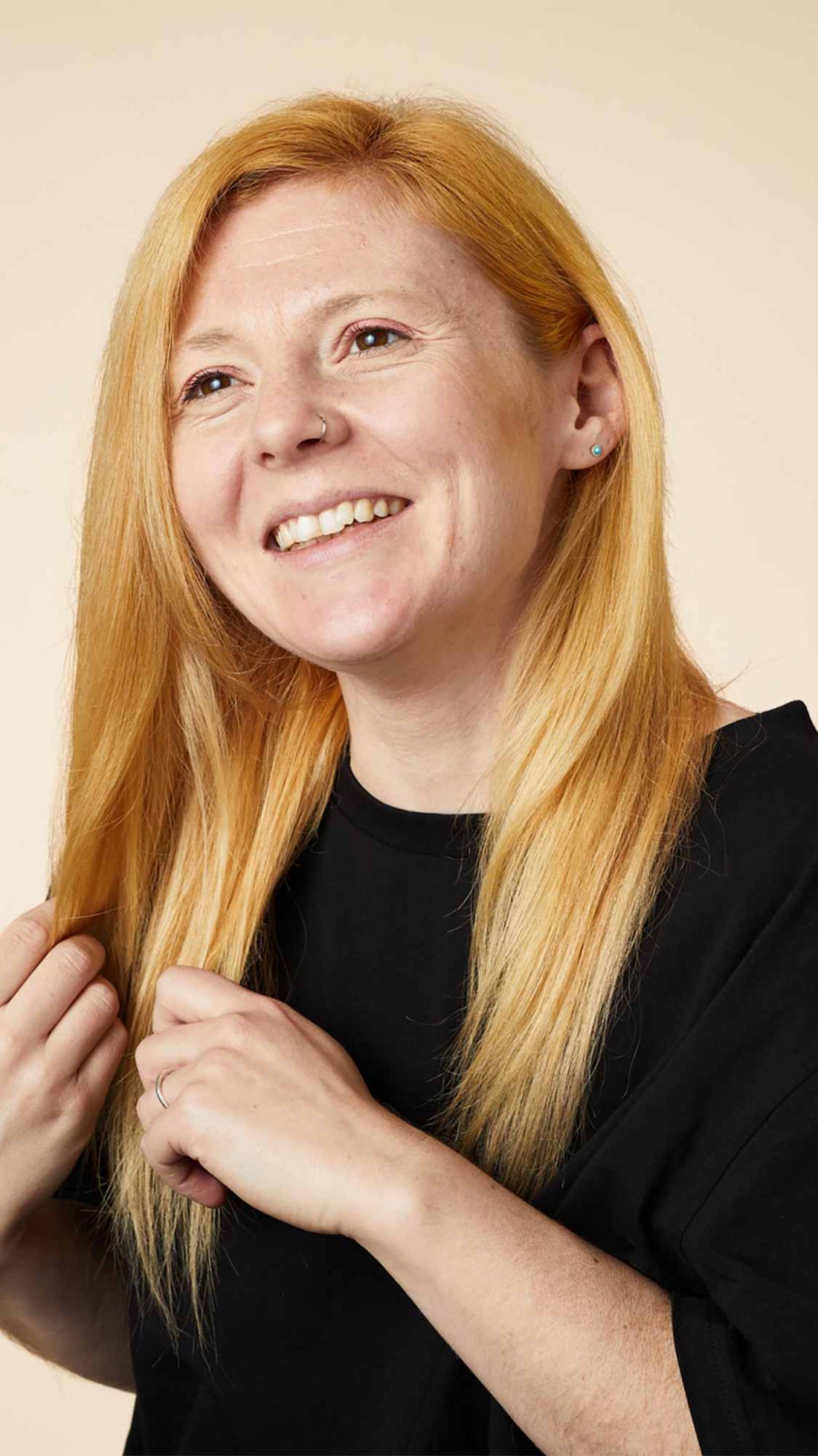 Woman smiling and showing off her hair after using Lush&