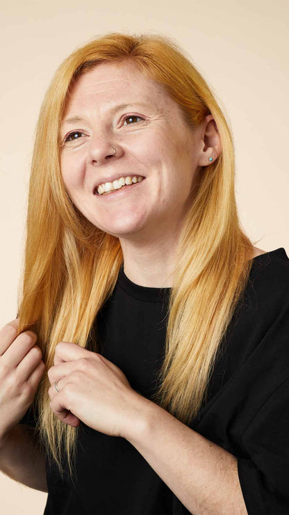 Woman smiling and showing off her hair after using Lush&